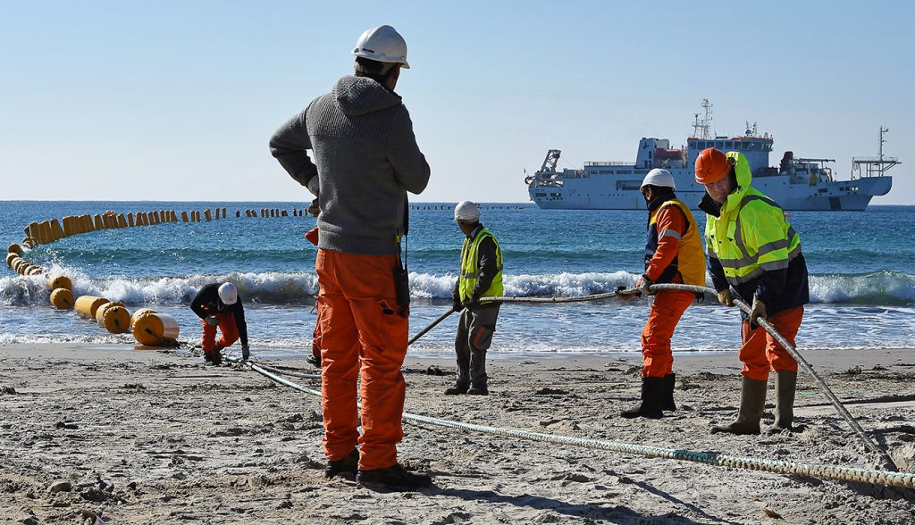 Employees of Orange Marine work on the installation of the very high speed submarine cable "SEA-ME-WE 5" linking  Singapore  to France, on March 1, 2016 in La Seyne-sur-Mer, southern France.
Thick like a tennis ball, with four optical fiber and 20.000 kilometer long (12,4274 milles), the cable connects 17 differents countries and should be commissioned for the second semester of 2016.
 / AFP / BORIS HORVAT        (Photo credit should read BORIS HORVAT/AFP/Getty Images)