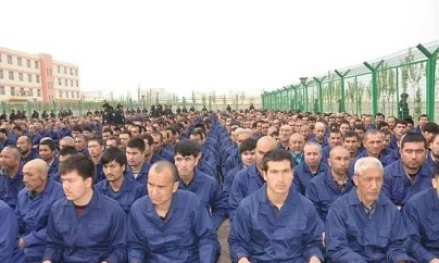 אסירים אויגורים מאזינים לנאום, במחנה לחינוך מחדש בשין-ג'יאנג, סין | תמונה: 牙生