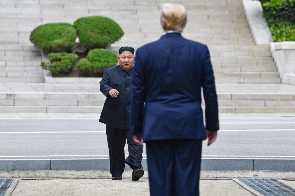 TOPSHOT - North Korea's leader Kim Jong Un walks to greet US President Donald Trump at the Military Demarcation Line that divides North and South Korea, in the Joint Security Area (JSA) of Panmunjom in the Demilitarized zone (DMZ) on June 30, 2019. (Photo by Brendan Smialowski / AFP)        (Photo credit should read BRENDAN SMIALOWSKI/AFP via Getty Images)