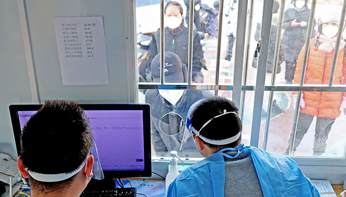 אנשי צוות עובדים במתקן שירות רפואי במחוז ג'יאנגסו בסין, 22 בדצמבר 2022. צילום: STR/AFP via Getty Images