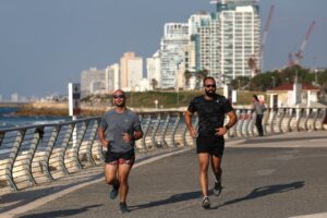 גברים רצים בתל אביב, 28 בדצמבר 2023 | AHMAD GHARABLI/AFP via Getty Images