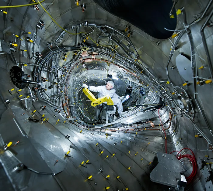 טכנאי מטפל בתעלת הפלזמה של מתקן ונדלשטיין 7-X