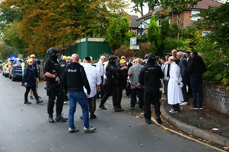 כוחות ביטחון ומתפללים מחוץ לבית הכנסת היתון פארק במנצ'סטר, 2 באוקטובר 2025