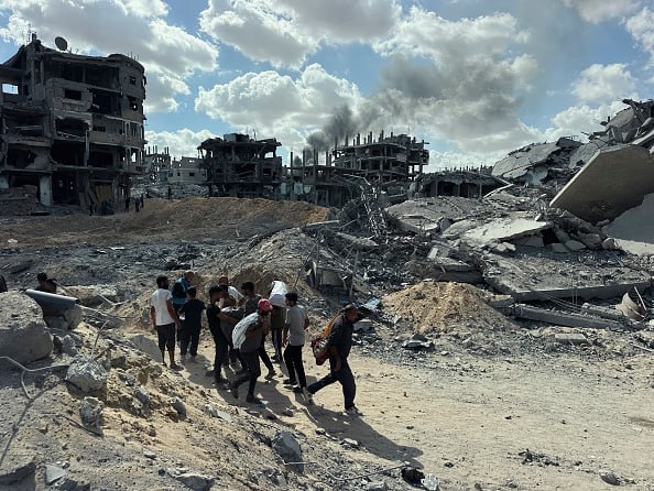 עזתים על רקע ההריסות ברצועת עזה