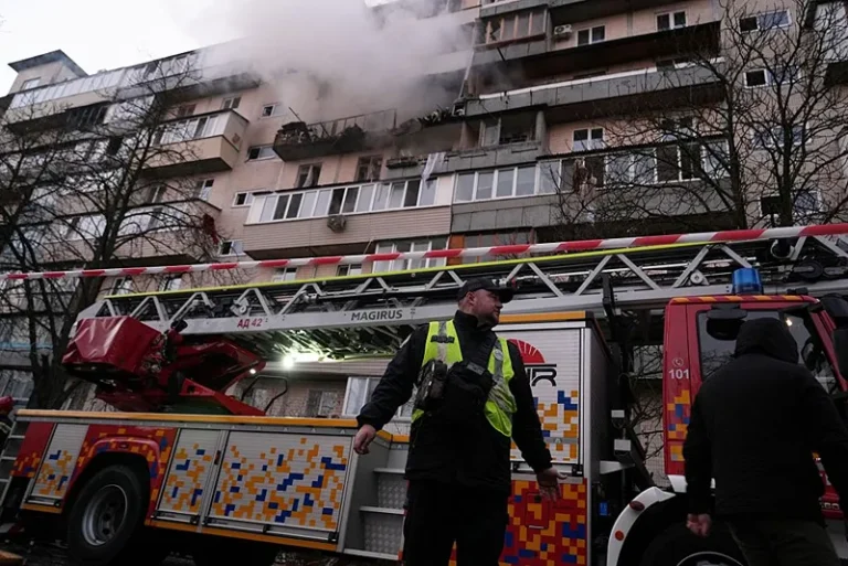 שוטר אוקראיני לצד מבנה שניזוק מתקפה הרוסית על קייב הלילה