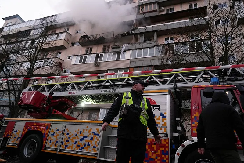 שוטר אוקראיני לצד מבנה שניזוק מתקפה הרוסית על קייב הלילה