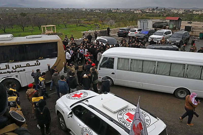 כוחות ביטחון סורים וכוחות הצלב האדום לצד אוטובוסים ובהם שבויים, במהלך טקס עסקת חילופי השבויים בסוריה היום