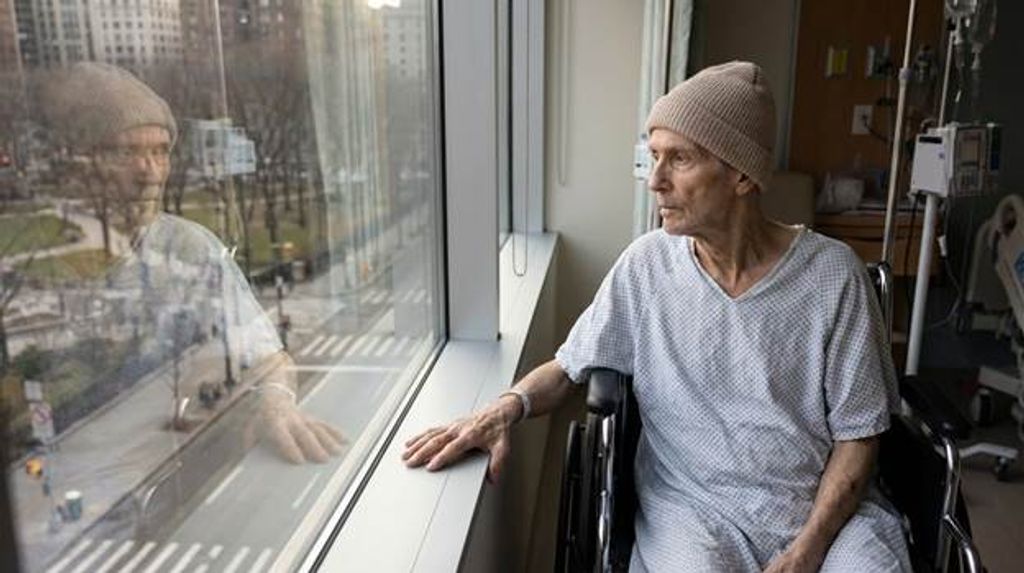 אדם הלוקה בסרטן מביט דרך חלון בית חולים