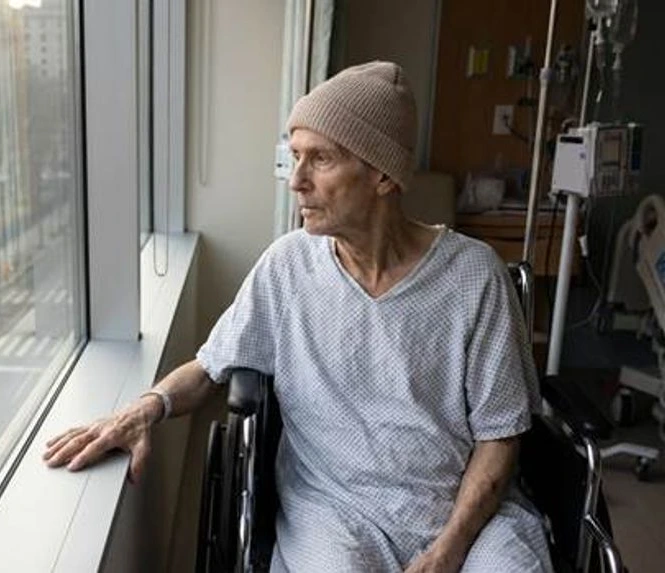 אדם הלוקה בסרטן מביט דרך חלון בית חולים