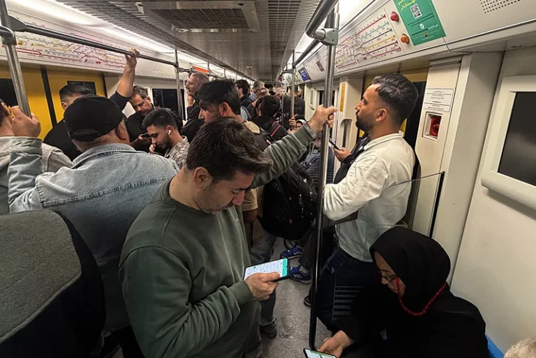 נוסעים ברכבת התחתית בטהראן משתמשים בסמארטפונים, 13 באפריל 2026