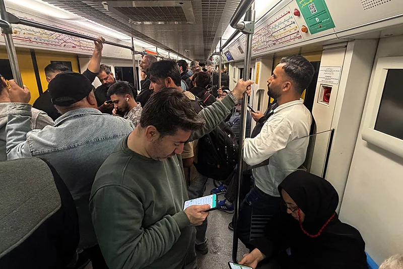 נוסעים ברכבת התחתית בטהראן משתמשים בסמארטפונים, 13 באפריל 2026